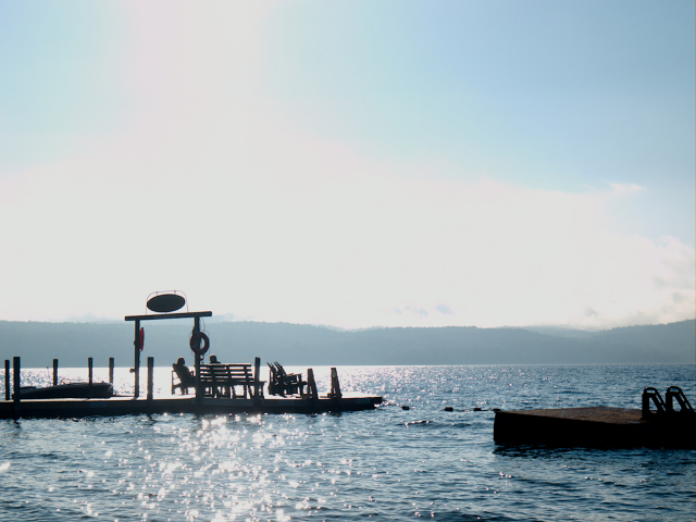 Sun glinting off the lake by the swimming raft and main dock